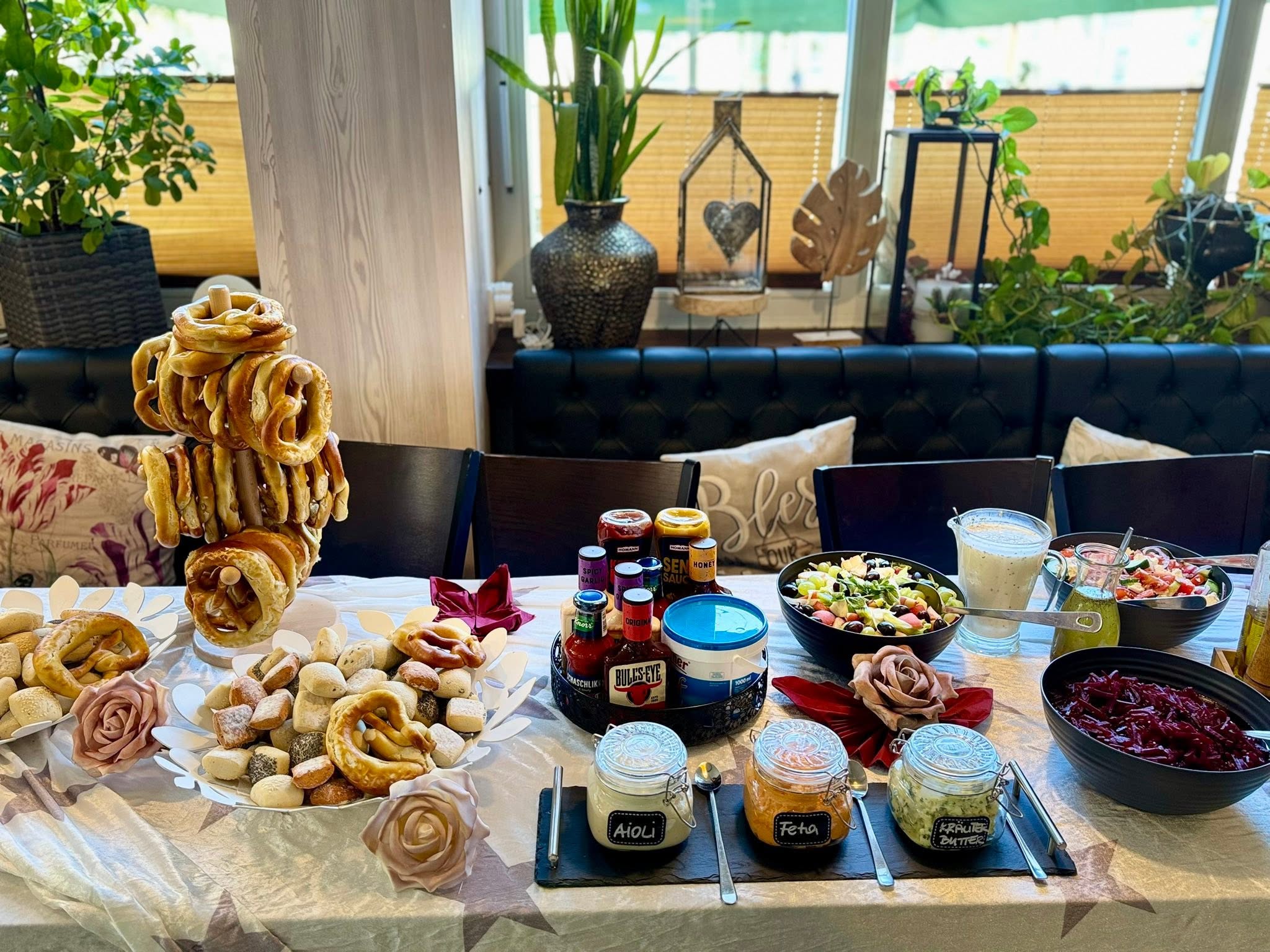 Liebevoll vorbereitetes Buffet mit Gebäck, Salaten und hausgemachten Dips