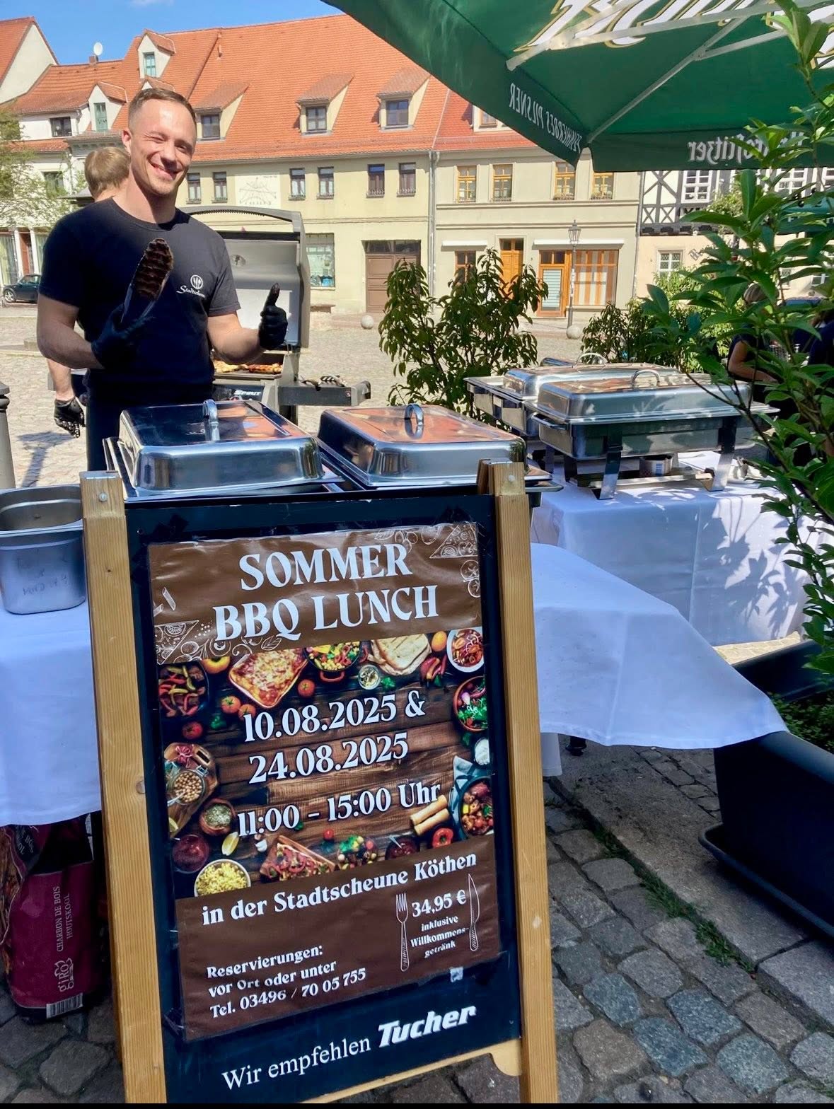 Sommerliches Grillbuffet mit einem Gastgeber vor der Stadtscheune